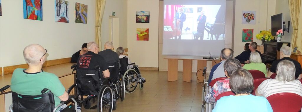 Seniorzy oglądają film na kinowym ekranie projekcyjnym
